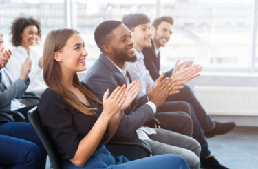 Business seminar. Colleagues clapping hands in office