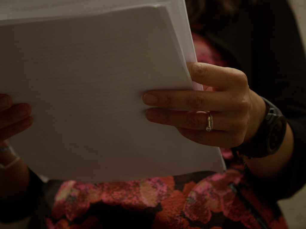 Woman holds pages, ready to write business story.