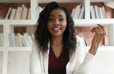 African businesswoman looking at camera make videocall talking with client