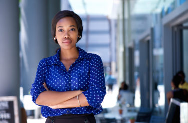 Confident young african american woman standing in the city