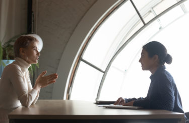 Confident Indian hr manager holding interview with candidate in office