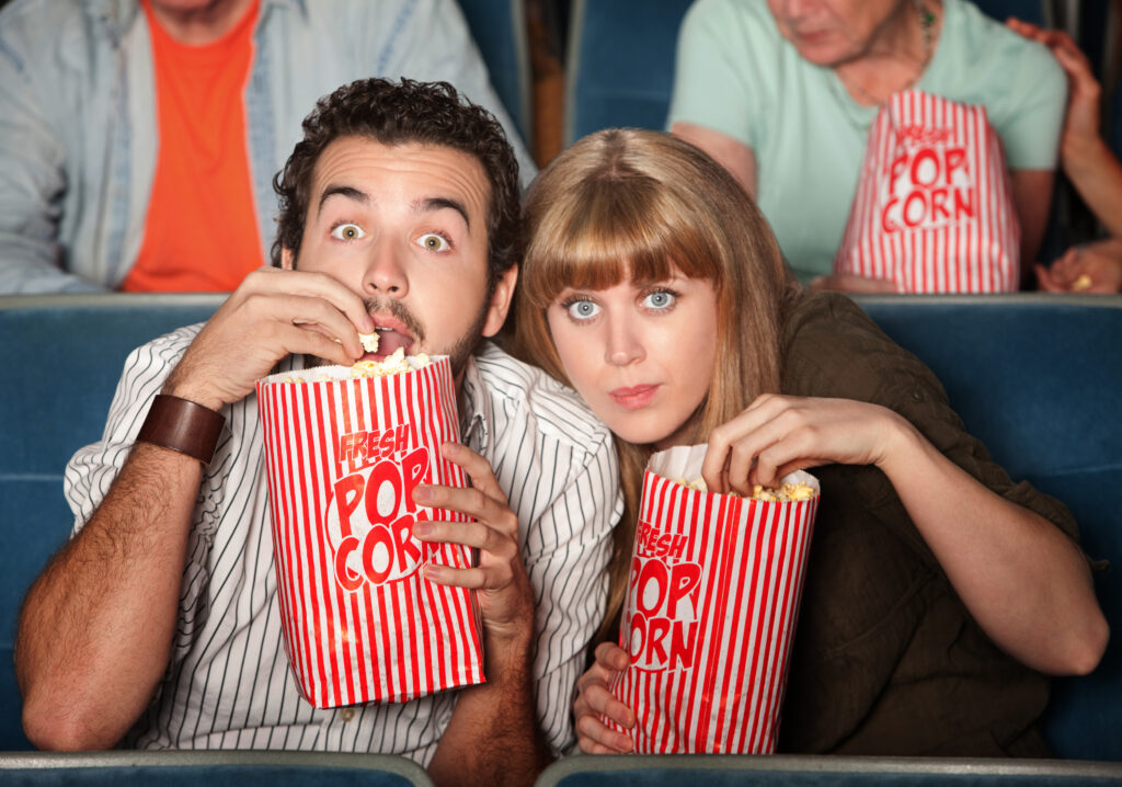 A couple in an audience shows suspense and intrigue