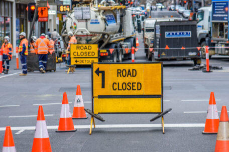 Melbourne, Victoria, Australia, July 31st, 2022: Workers are wearing high visibility clothing while performing roadworks behind a 'Road Closed' sign
