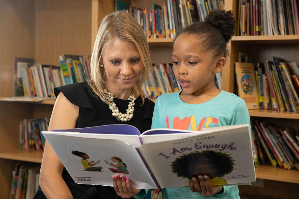 Erin Porteous reads with child at the Boy and Girls Club Denver