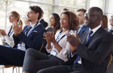 Smiling audience applauding at a business seminar