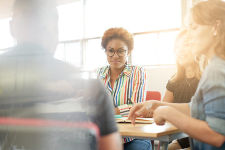 Candid picture of a business team collaborating. Filtered serie with light flares, bokeh  and warm sunny tones.
